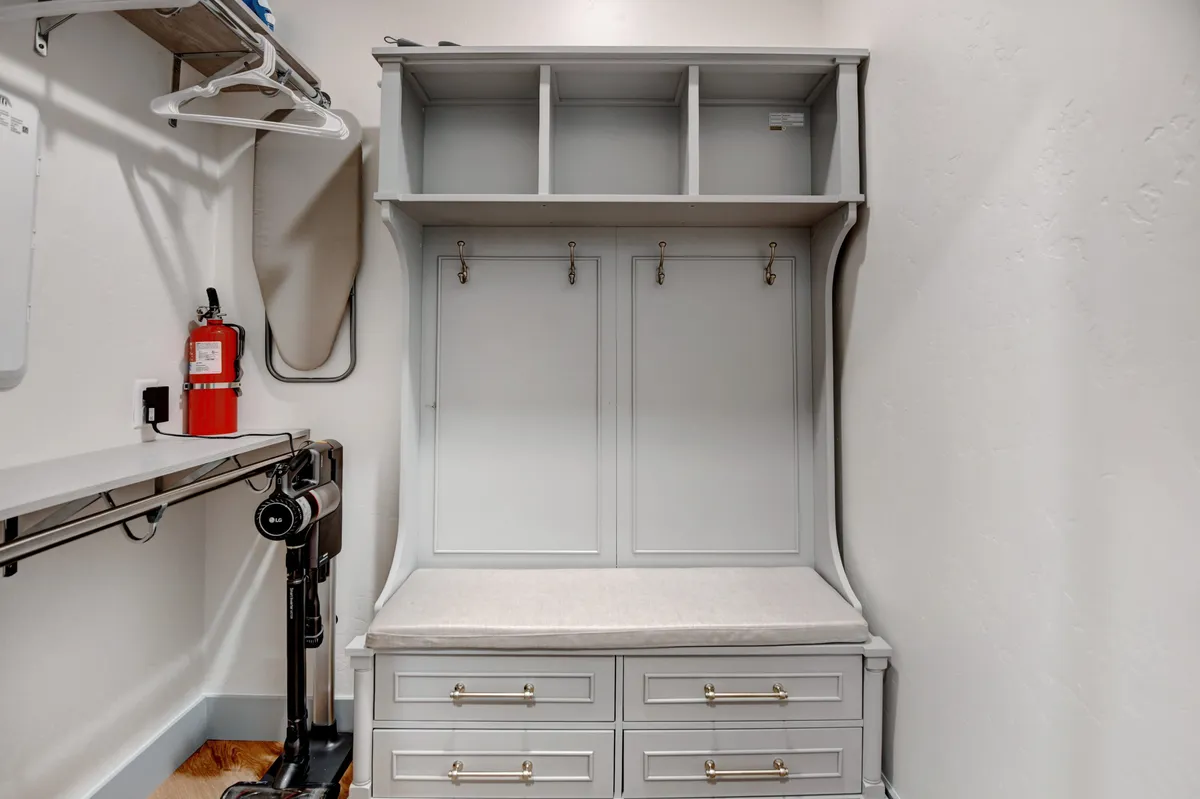 This image shows a welcoming mudroom area with a bench, hooks for coats, storage drawers, and shelves—spaces full of outdoor gear ready for mountain adventures. The scene hints at the rhythm of guests coming and going, storing hiking boots or ski jackets as they explore the local area throughout the changing seasons.